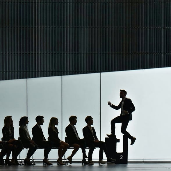 image showing interviewees waiting for an interview and a person jumping the queue or being selected ahead of the crowd